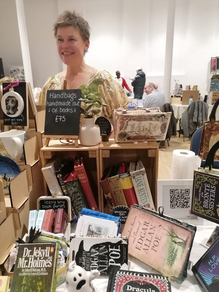 A trader of artisan products chats to  visitors