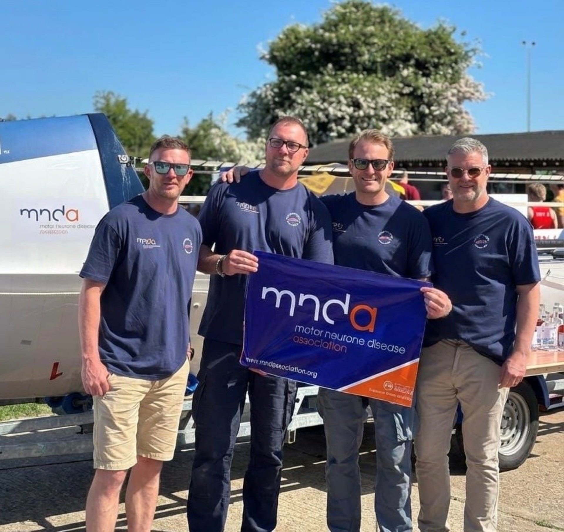 Four men stand in front of boat for MND Northampton