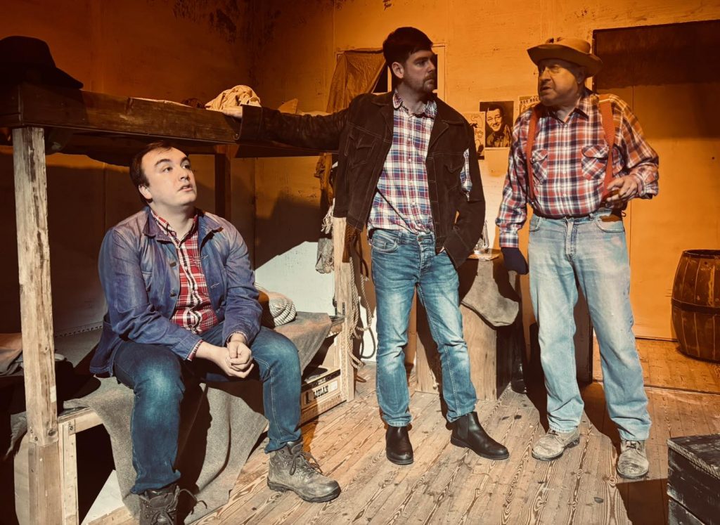 Three men in The Playhouse Theatre Production Of Mice and Men