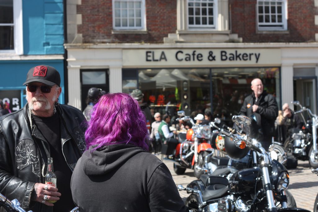 A man and a lady with purple hair and Harley bokes