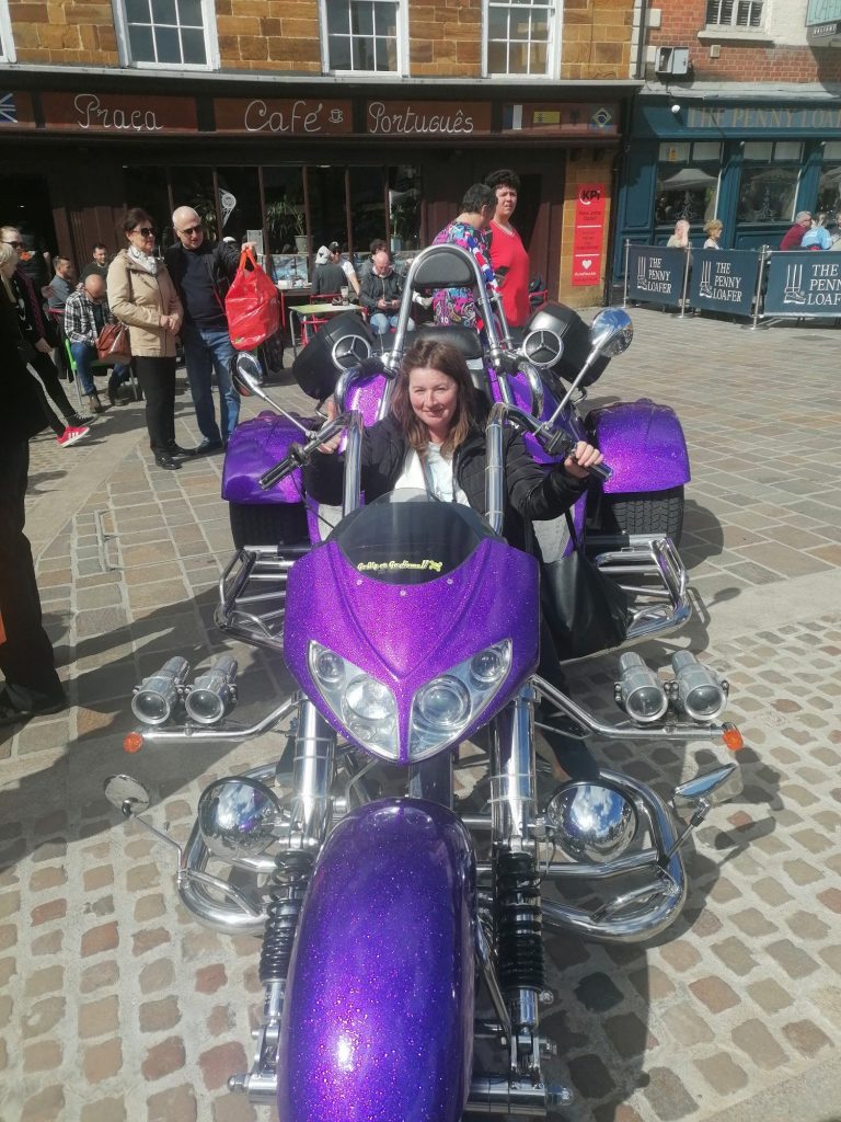 A lady in a purple harley