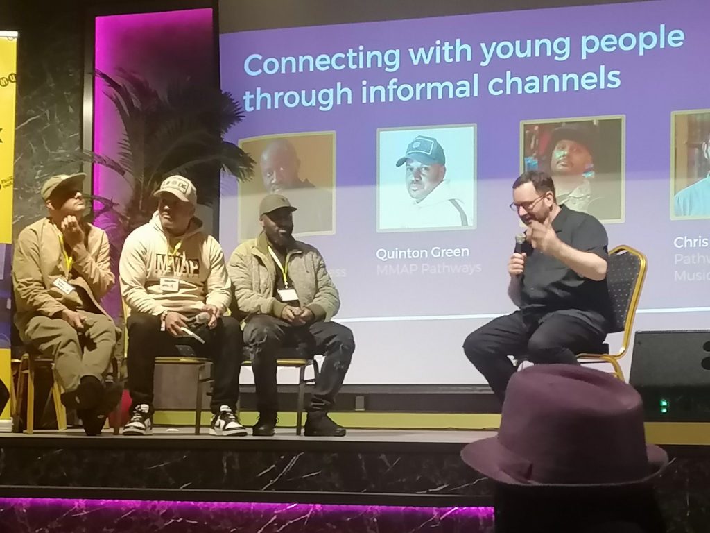 Quinto Green and two other men talk at a recent music conference. 