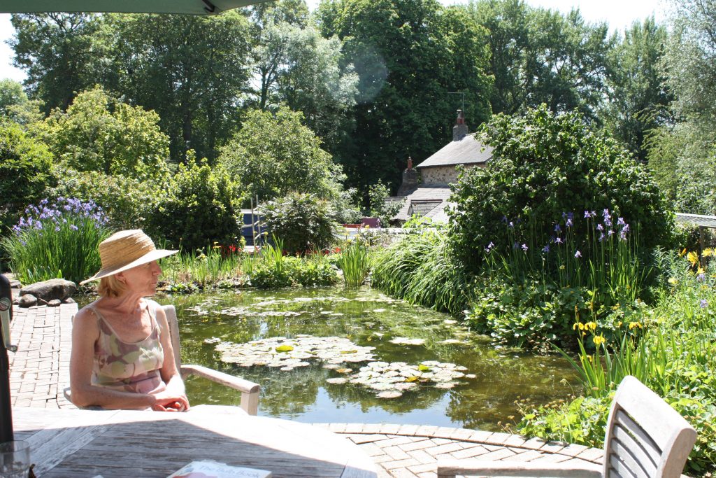 lady sits enjoying her garden
